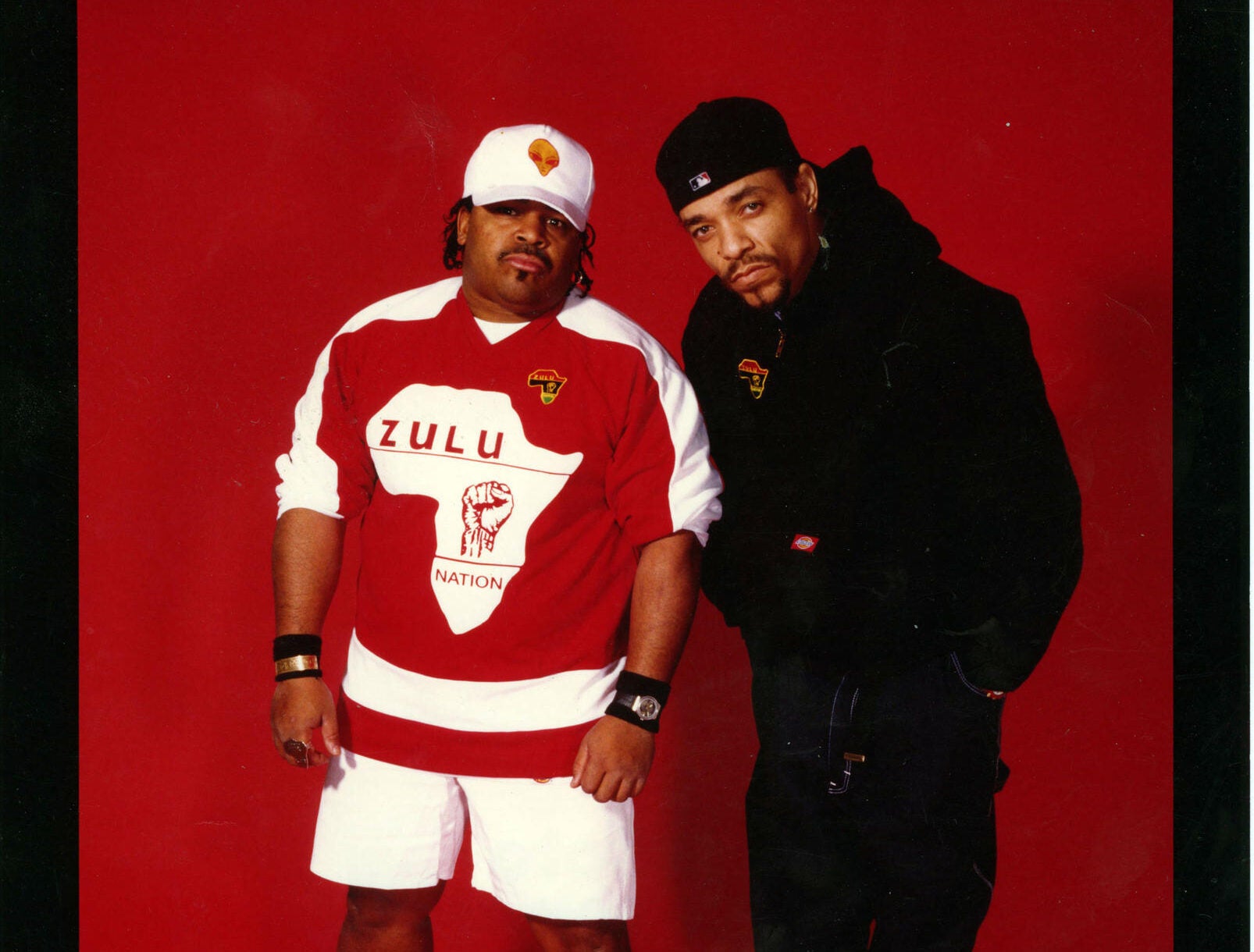 Two rappers in front of a red background
